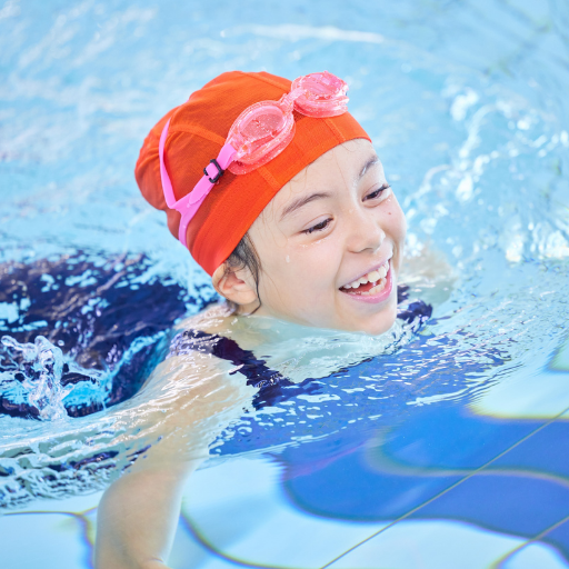 Criança com autismo feliz brincando na piscina, acompanhada com segurança