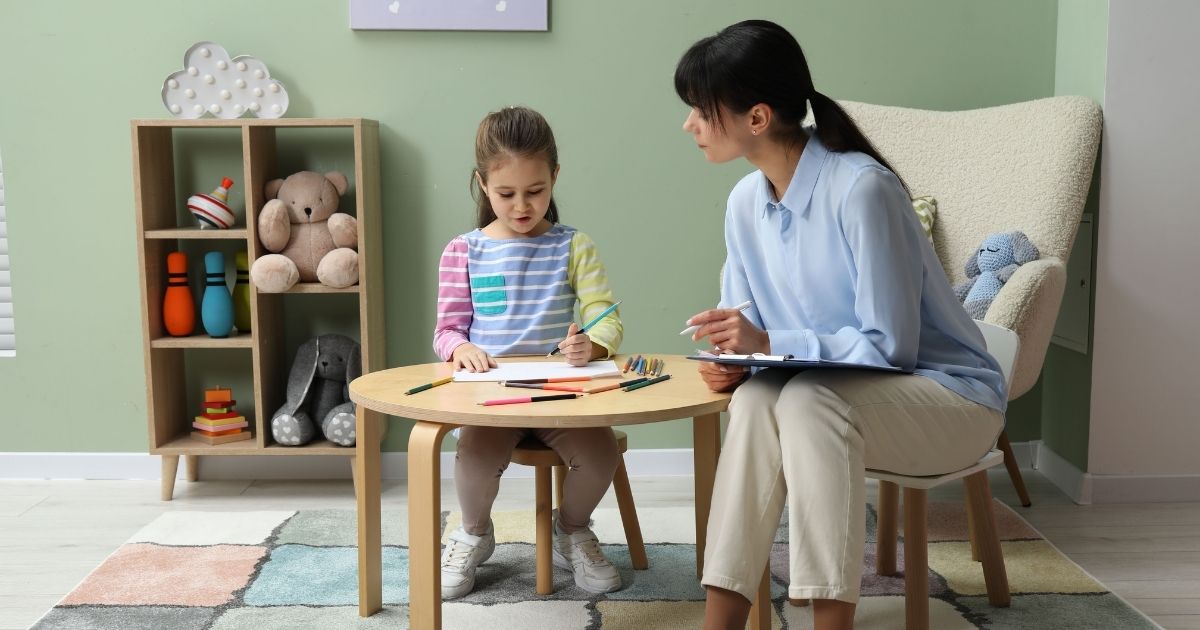 Profissional da saúde conversando com criança em avaliação de autismo