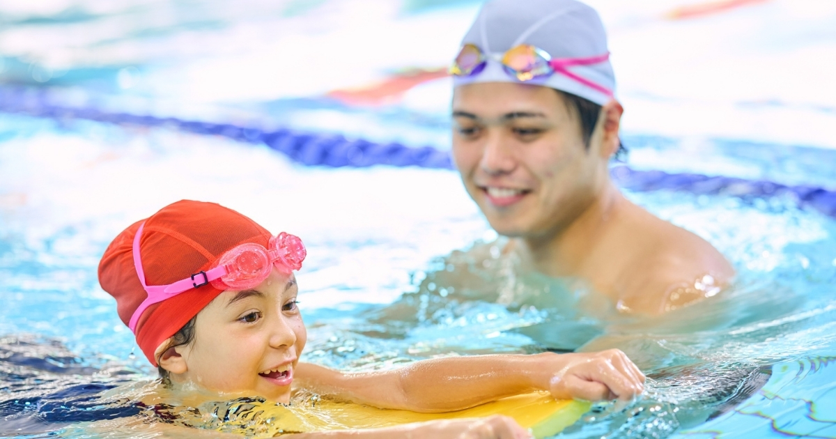 Instrutora aplicando o Método VIVA com criança autista em piscina com rotina adaptada