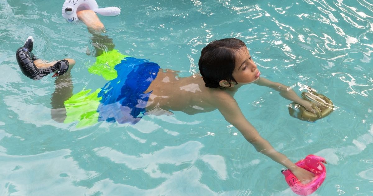 Criança no espectro autista explorando atividades aquáticas com alegria