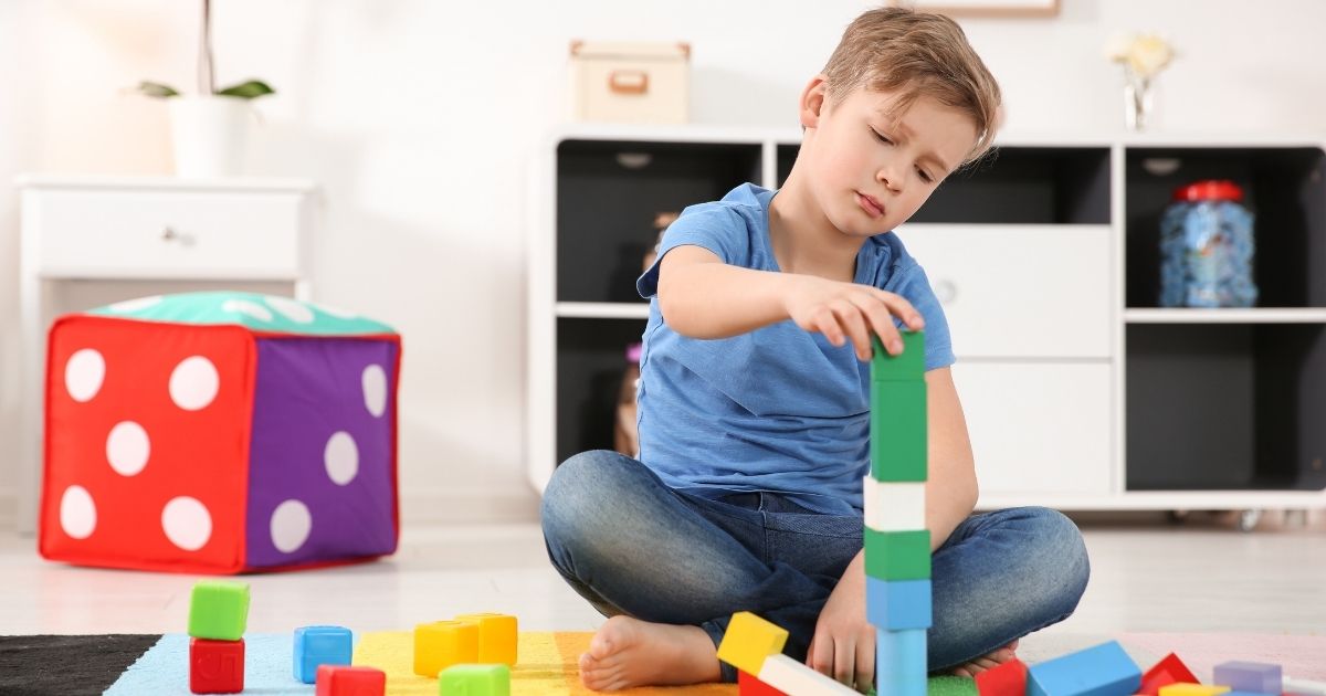 Criança pequena brincando com blocos coloridos que estimulam o desenvolvimento cerebral