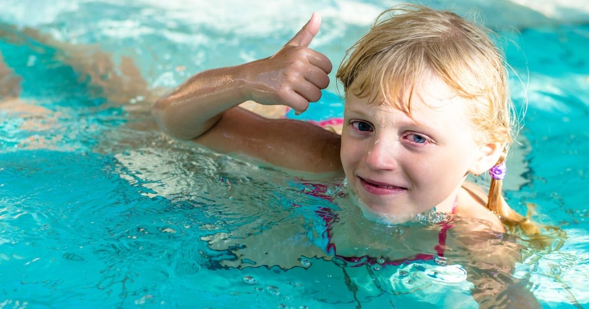Mãe aplicando atividade do Método VIVA com o filho em uma piscina tranquila