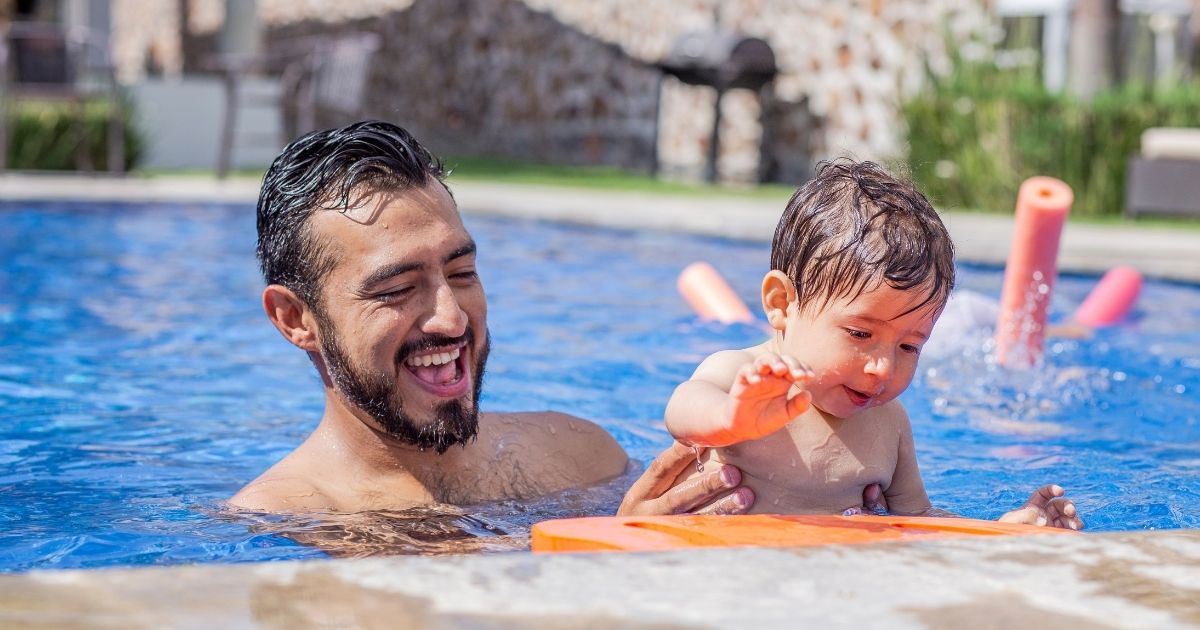 Mãe e filho brincando juntos na piscina, reforçando vínculo e confiança.