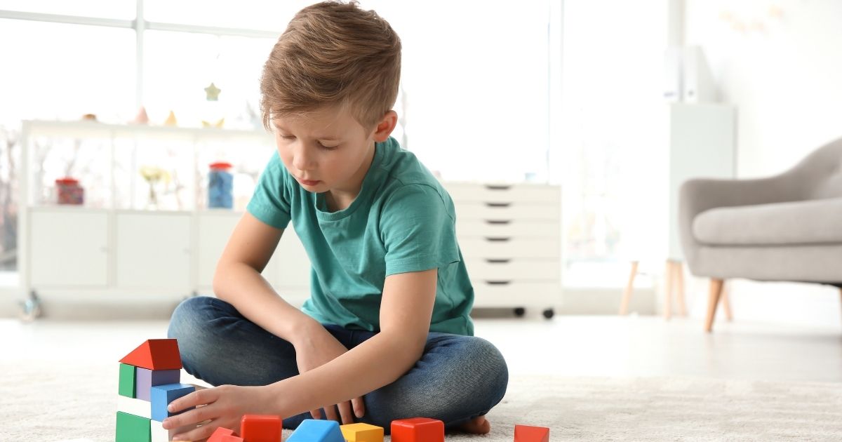 Criança com TEA realizando atividade psicomotora com apoio de brinquedos sensoriais